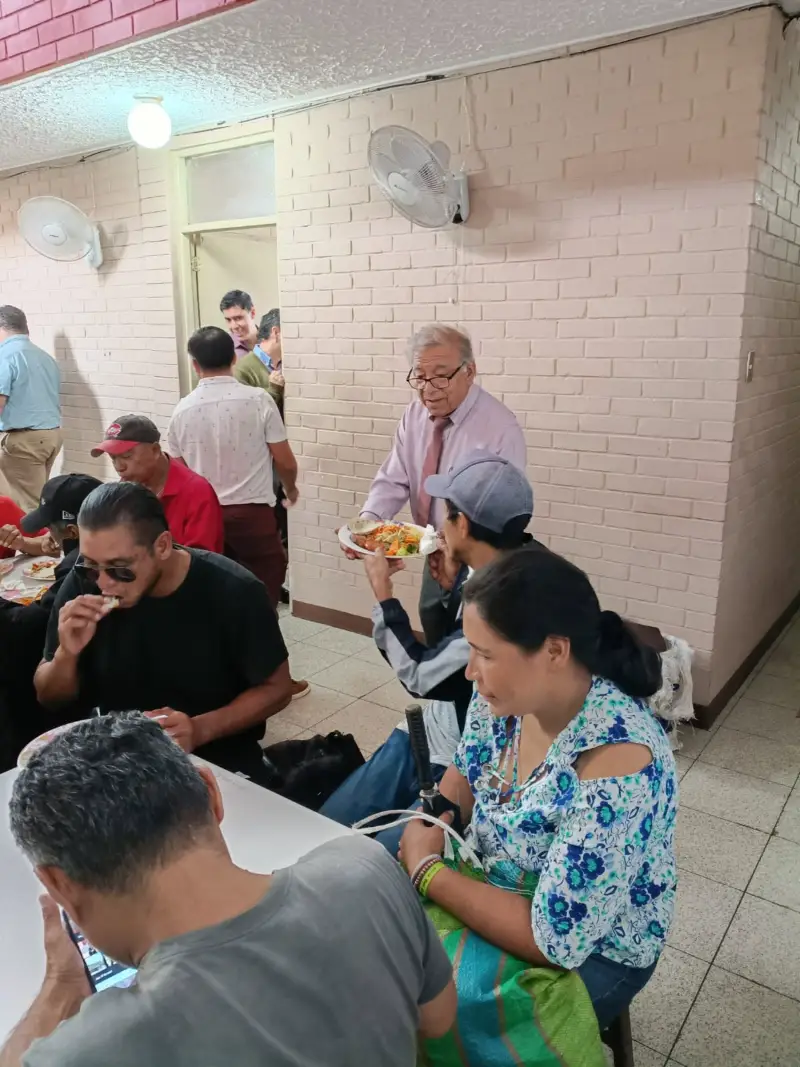 Un voluntario sirve un plato de comida en el comedor
